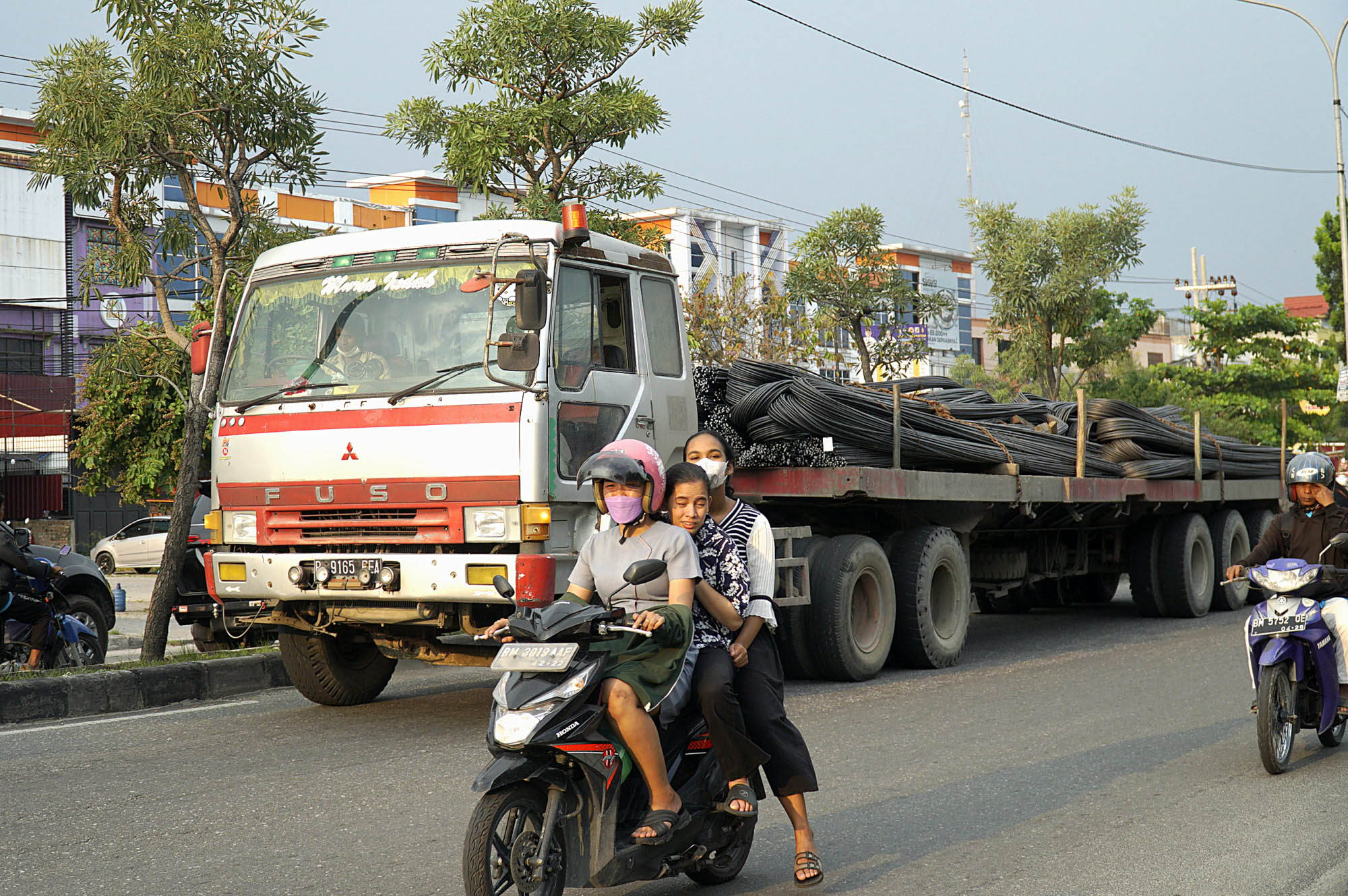 Truk bertonase berat di antara pengendara motor saat melintas di Jalan HR Soebrantas siang hari, beberapa waktu lalu.